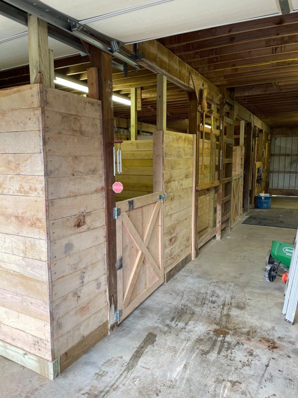 Freshly built stalls in a barn by Oak and Iron Farm Fence